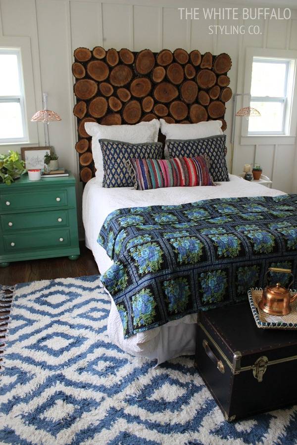 A bed with a headboard that looks like a stack of logs.