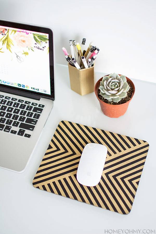 A laptop is sitting on the table near pens and a mousetop.