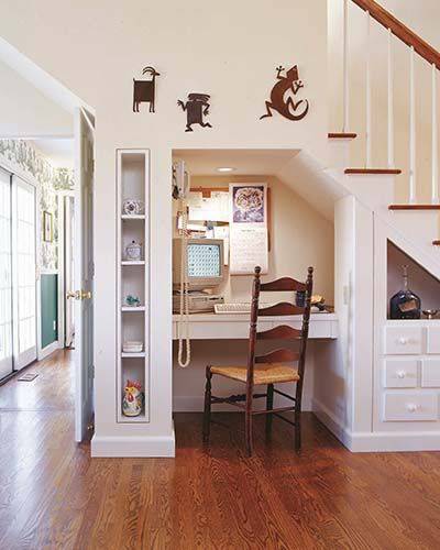 Desk nook underneath stairs with shelving.