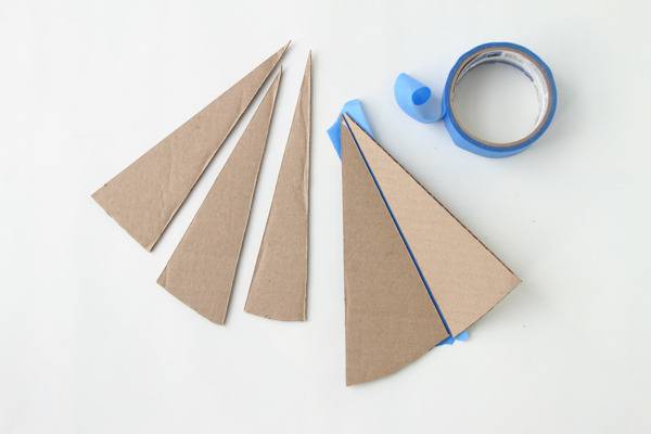 Scrap board triangle pieces attached with blue color tape.