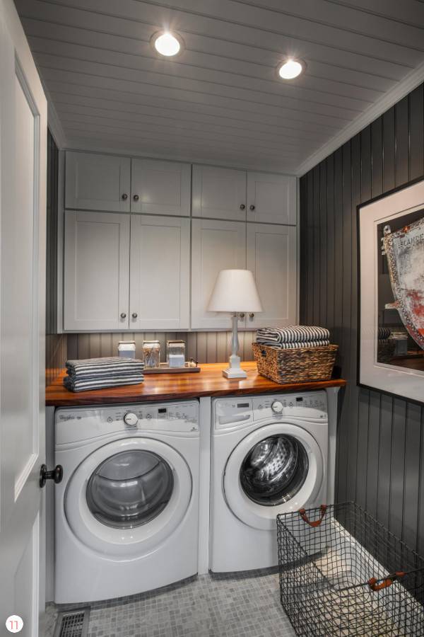 A dimming laundry room with white cabinets