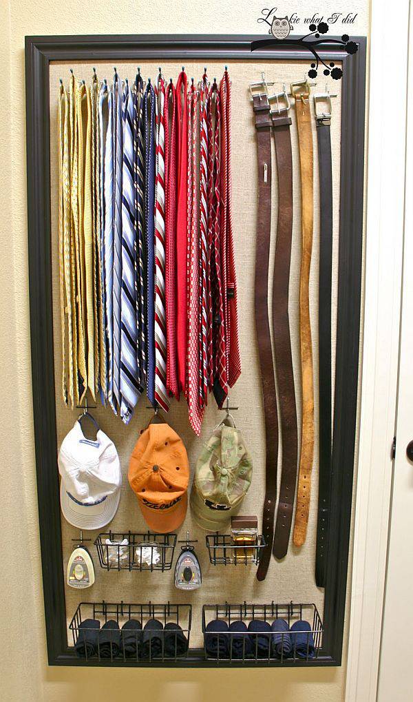 Small closet with ties, belts, caps, towels and scent bottles.