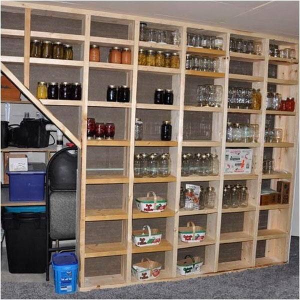 Wooden garage organizer with multiple compartments with glass jars sitting them.
