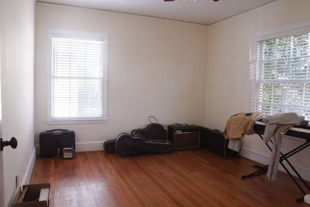 Wooden baby crib with drawers near wall decorated with animal motif.