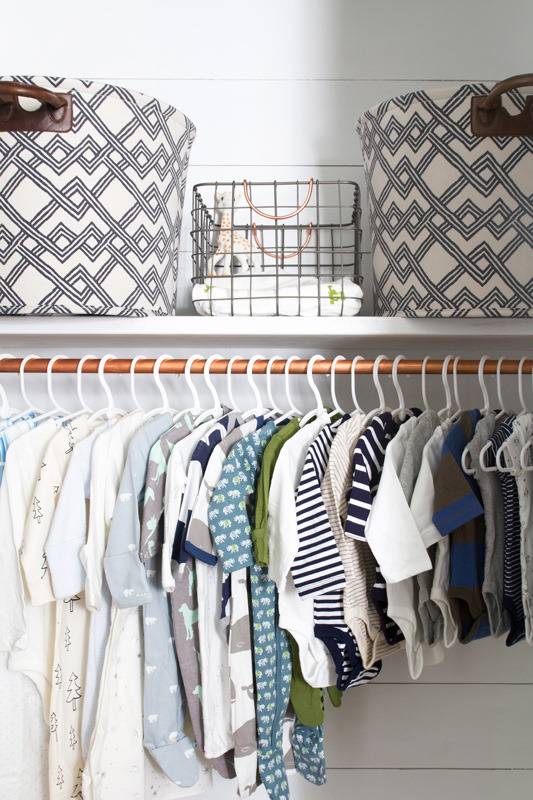 "Boxes are in upper portion and dresses are hanging in under portion of the cupboard."