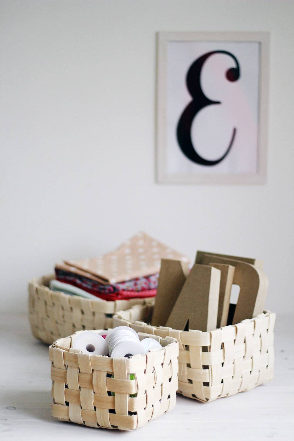 Clothes baskets with cardboard sitting below a picture of an E.