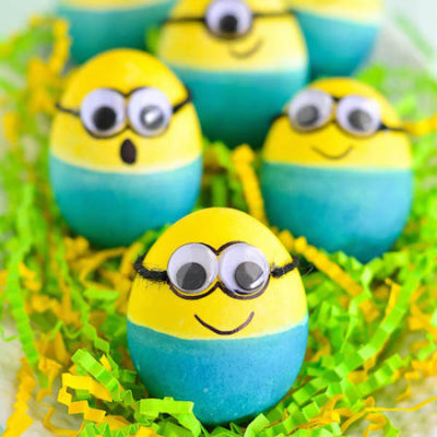 Yellow and blue eggs painted to look like minions for Easter sit in a bowl.