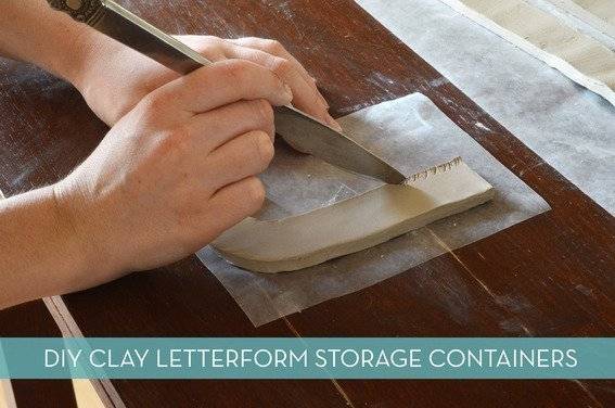 A person is cutting clay with a knife on a wooden surface.