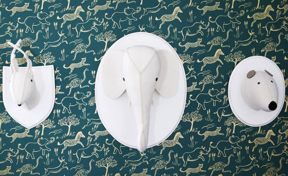 Deer, elephant, and panda wall statues are place to a forest designed wall.