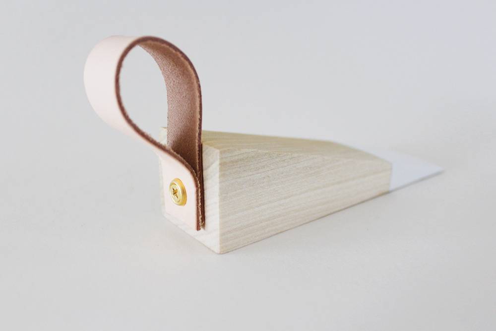 A triangle piece of wood, white at the tall end and a felt loop on the wide end.