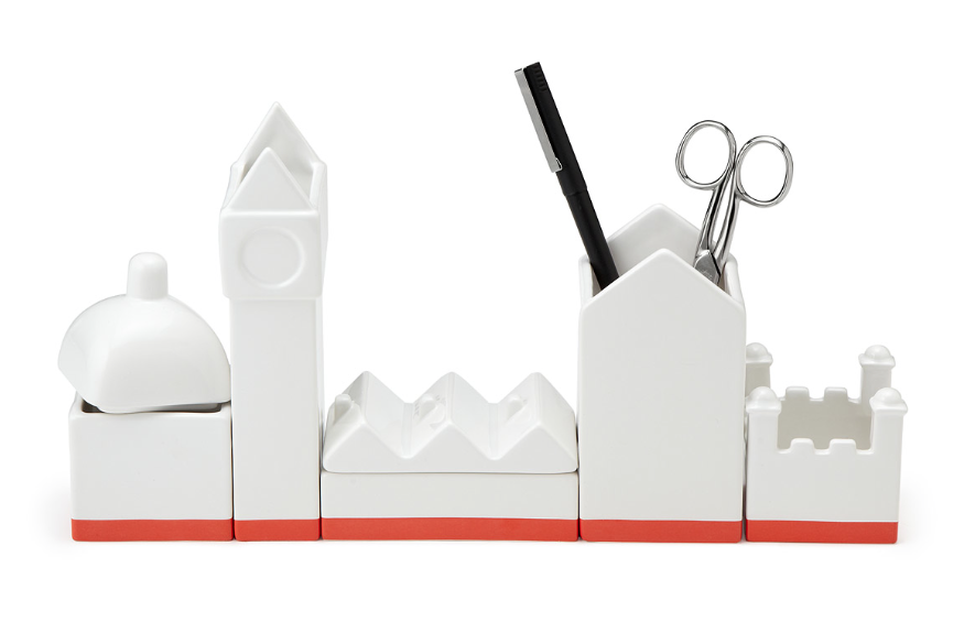 A white organizer shaped of a clock tower and castle.  In it a pair of scissors