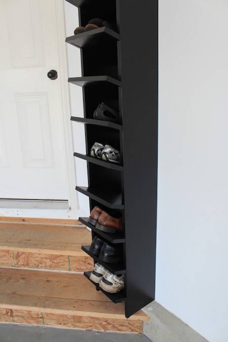 A tall black shelf has shoes on it.