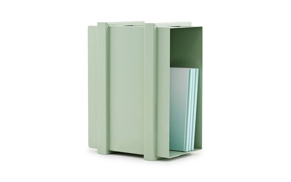 A green paper holder with things in it.
