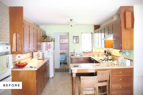 Stainless steel refrigerator and oven near cabinets with marble counter tops in a kitchen.