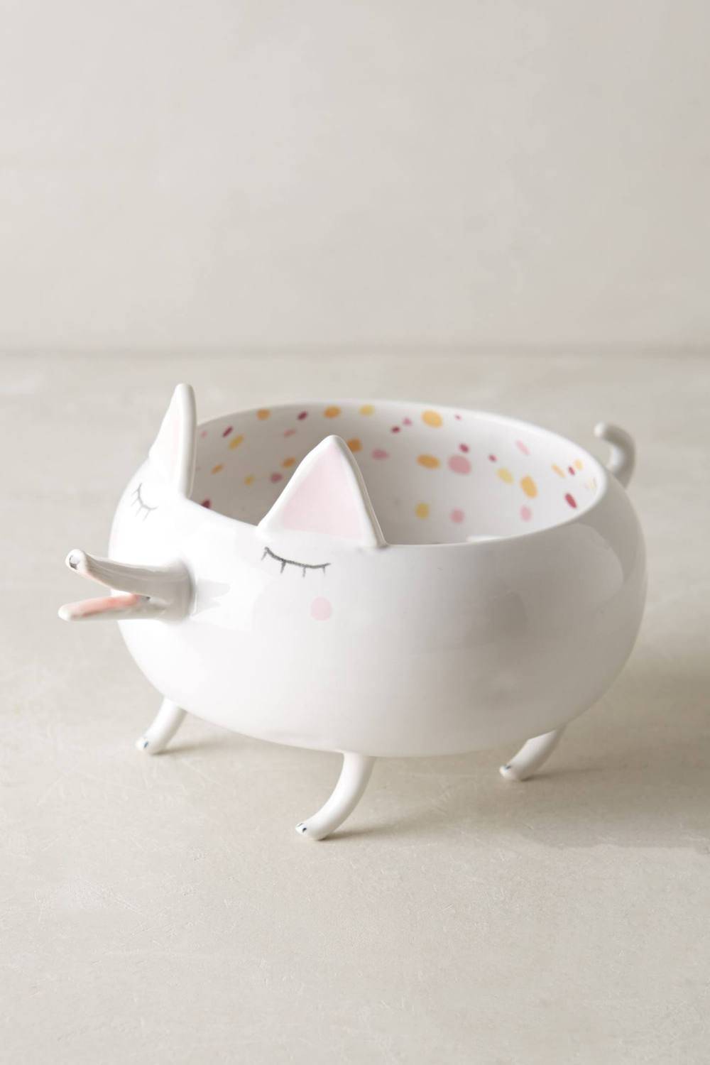 A cat shaped dish stands on four feet.