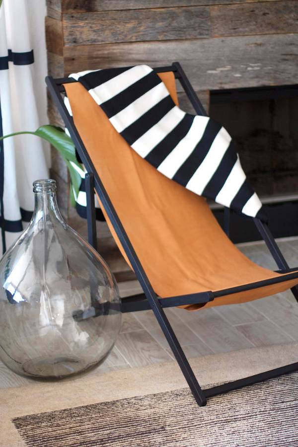A black and white towel is hung over an orange deck chair