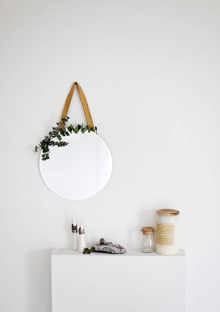 A white globe is hanging on the wall near a white table.
