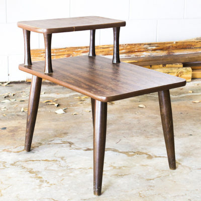 Dark wood side table with another small side table resting on top of it.