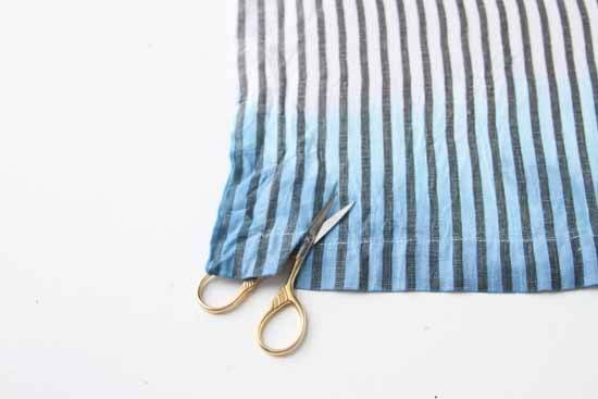 Making a cut in a piece of cloth with a scissor.