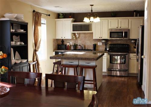 Kitchen cabinets with stove and microwave near a sink.