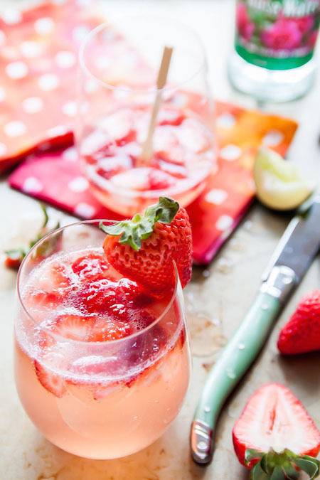 A cocktail with strawberries in it.