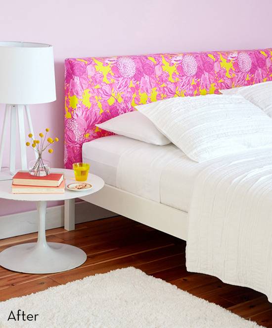 A bed with a pink and yellow headboard and all white sheets with a white rug and white side table with an orange book on it.