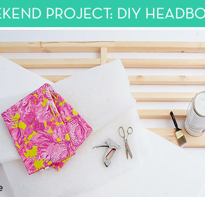 A pink and yellow piece of fabric lays on a white sheet with tools next to it.