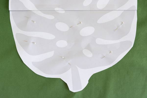 A white leaf is sitting on a green fabric.