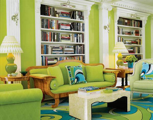 Green furniture and white shelves fill a room with bright green walls.