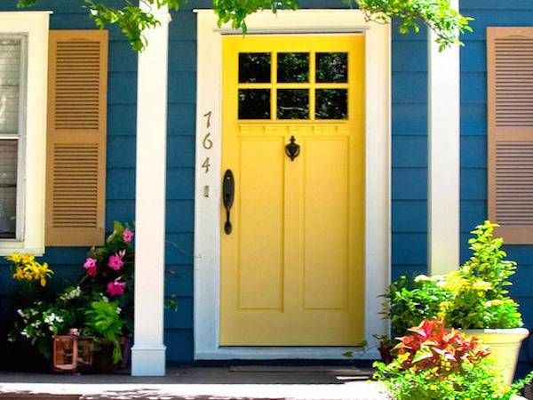 The door of a blue house painted in yellow.