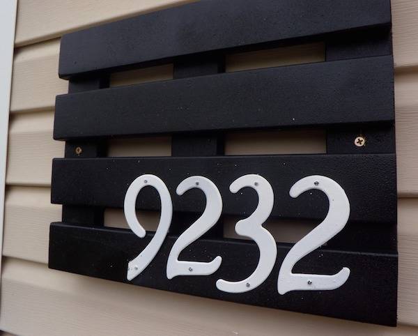 The number 9232 is written in white paint on a black pallet.