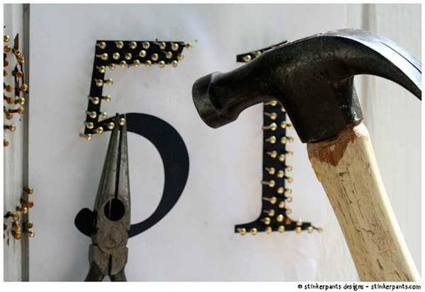 A hammer is nailing tacks into the number 51.
