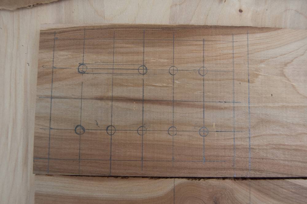 Lines and circles marked on a wooden piece.