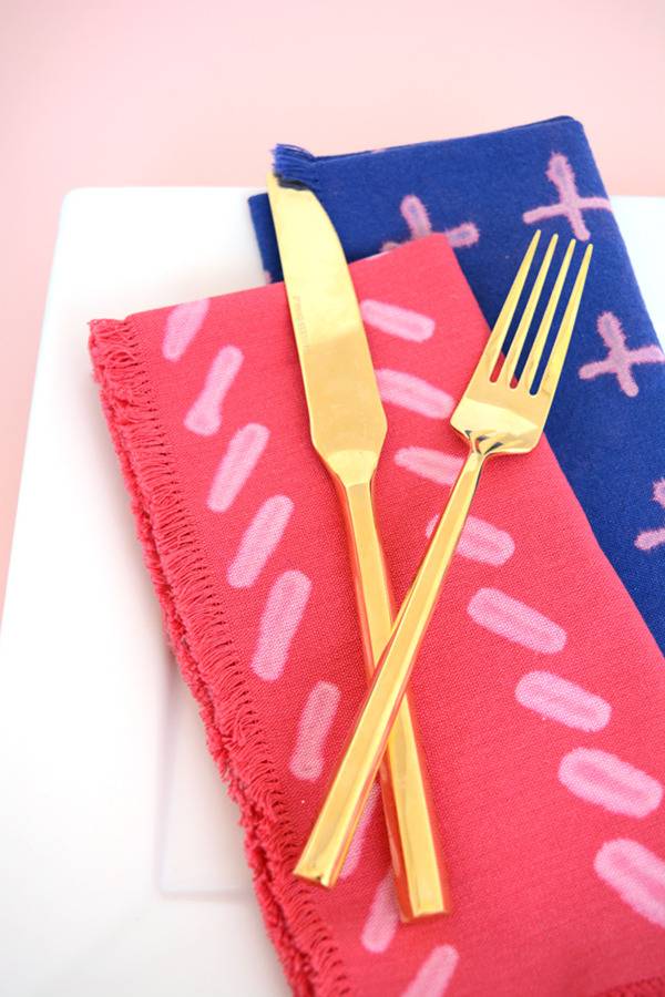 Garden silverware are on three colorful towels.