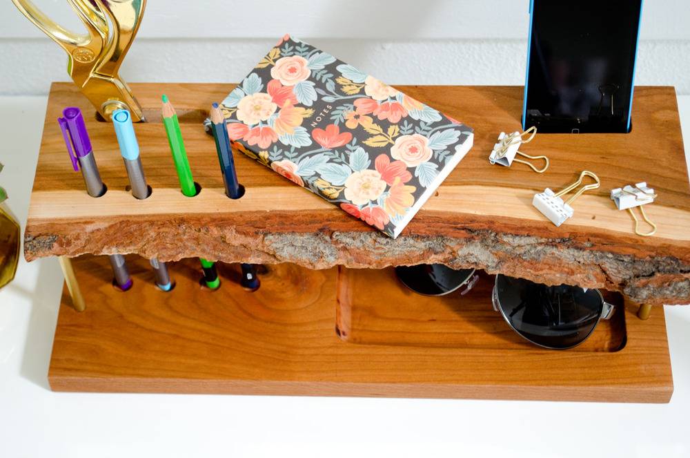 Pen holder stand with a book and some paper clips in it.