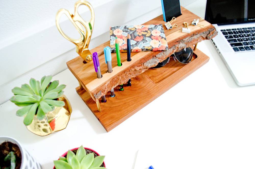 A brown mini table with colorful trinkets on top next to a laptop.