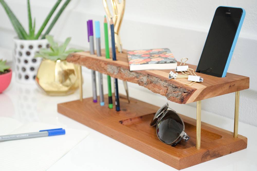 Desk organizer with mobile phone, goggles, pens, pencils, notebook and clips.