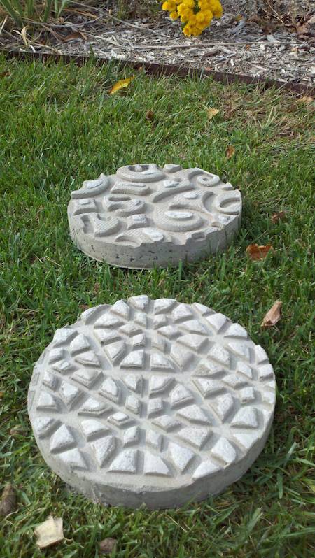 Pair of cement stepping stones with triangular designs.