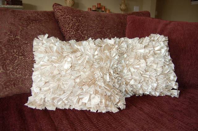 Two white pillows sit on a red bed with three red pillows behind them.