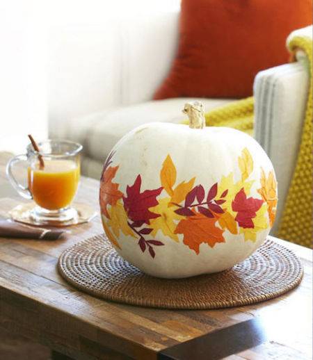 A pumpkin has been decorated with a yellow and red leafy pattern.