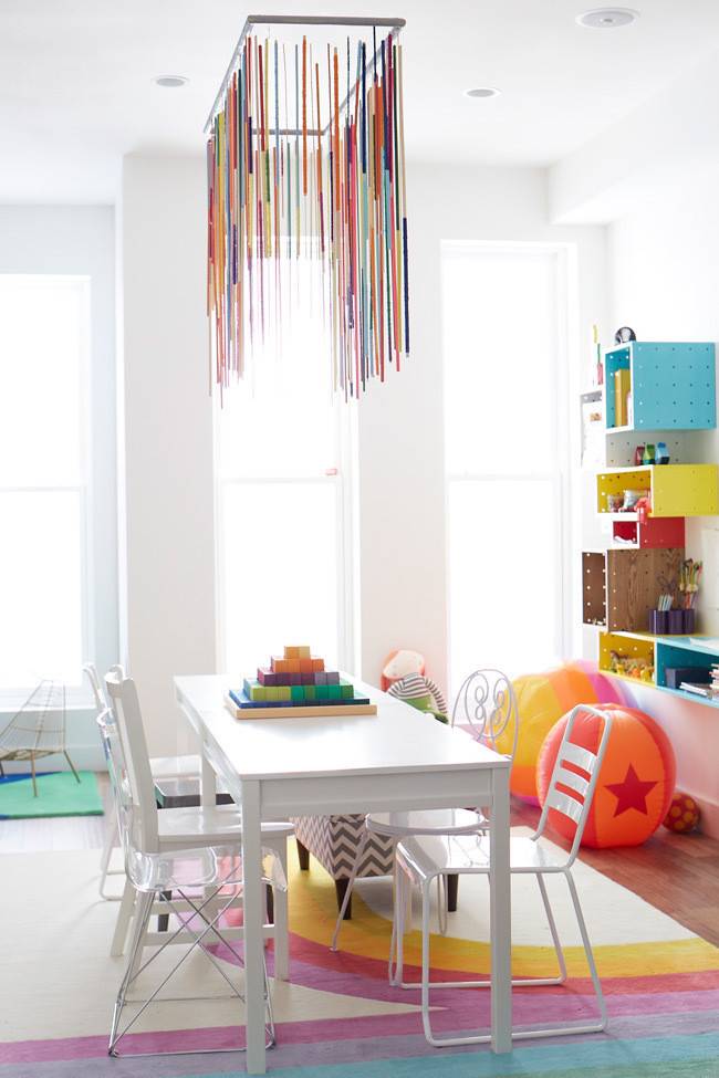 A white table surrounded by four chairs in a room with colorful decorative items.