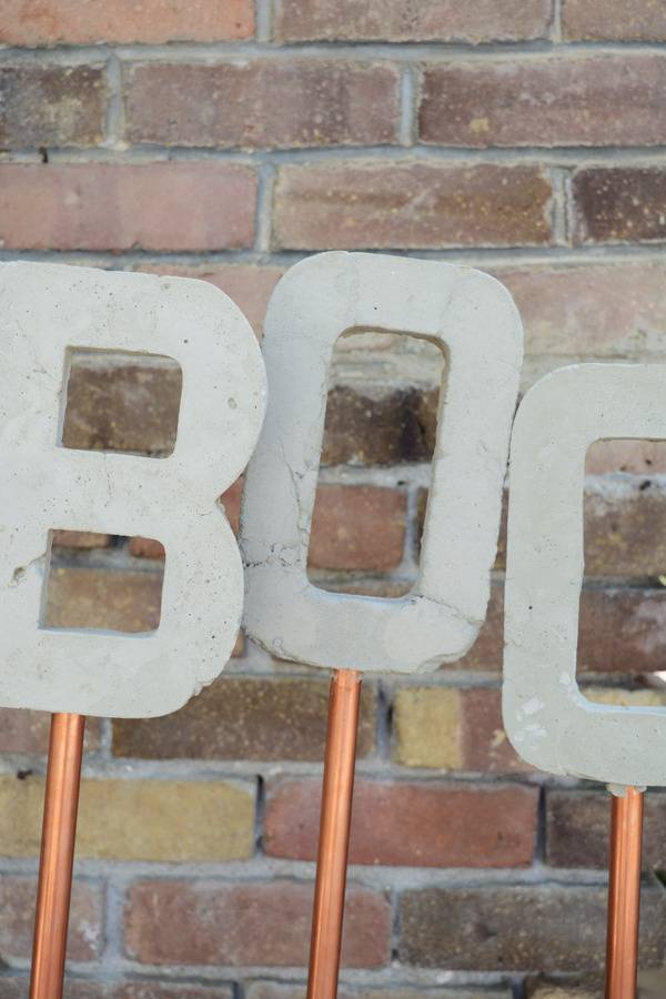 Three cut out letters on rods spelling out the word "boo."