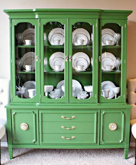 Green cabinet that holds fancy china.