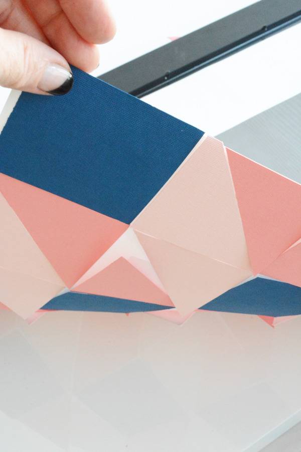 A person is moving a material in pink and blue colors.