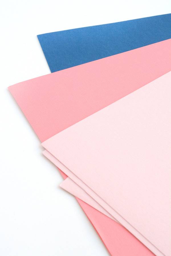 An array of napkin corners, one blue, one pink and one light pink.