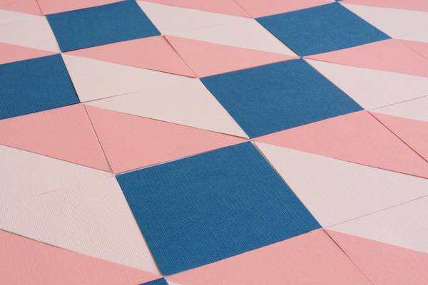 Blue tiles are interspersed between light and dark pink tiles.