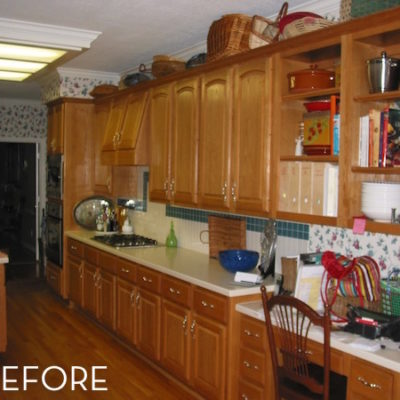 A before picture of a dated kitchen with brown wood cabinets and floors.
