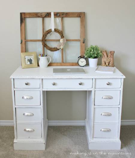 A madeover white desk with items on it.