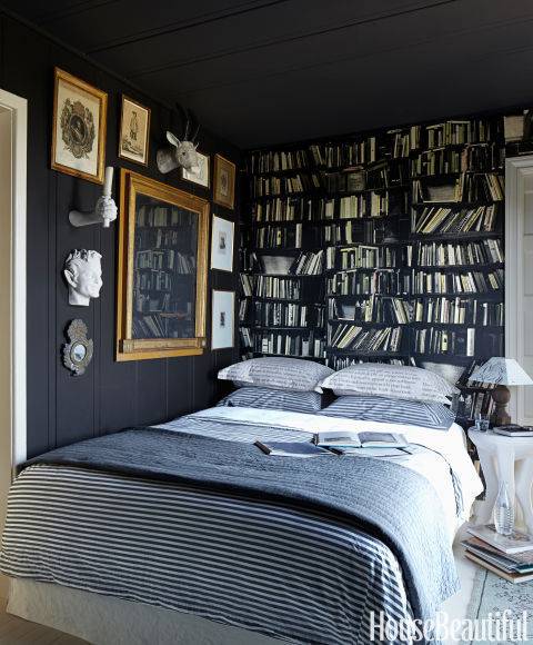 A room having black interior and lots of books.