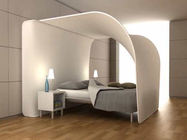 White canopy arching over the top of a bed in a room with a wooden floor.